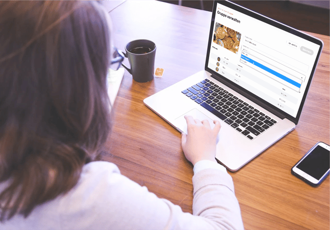 Frau sitzt mit Tee vor dem Notebook